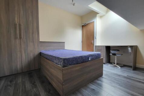 A cozy single bedroom featuring a comfortable b...