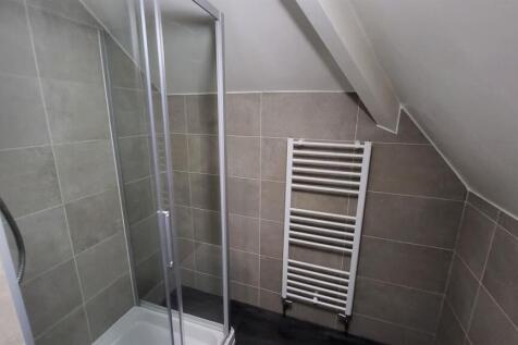 A modern bathroom featuring a spacious shower a...