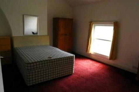 A modest bedroom featuring a single bed and a w...