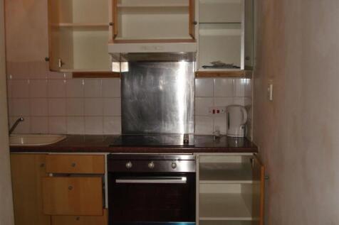 A functional kitchen area with wooden cabinets ...