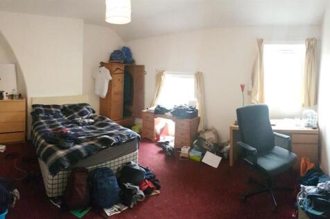 A cozy bedroom featuring a double bed with a pl...