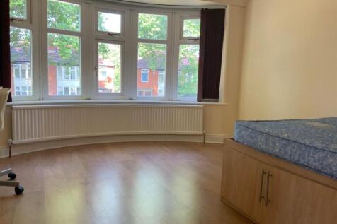 A bright and airy bedroom featuring a large win...