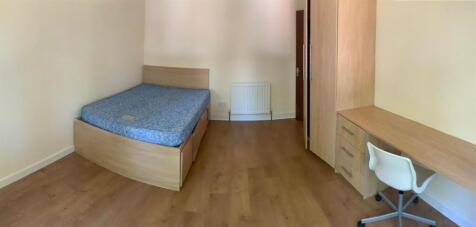 A tidy and well-lit bedroom featuring a comfort...