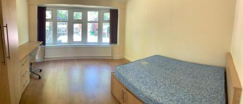 A well-lit bedroom with a large window allowing...