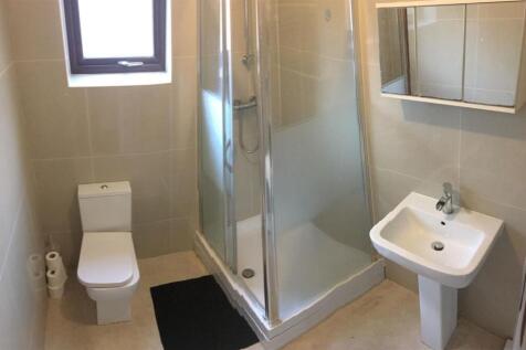 A modern bathroom featuring a shower cubicle, a...