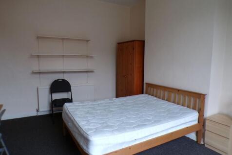 Bright, simply furnished bedroom with a wooden ...