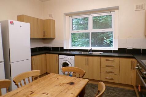 Bright kitchen with light wood cabinets, black ...
