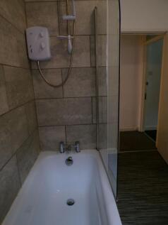 Modern bathroom with tiled shower-over-bath, gl...