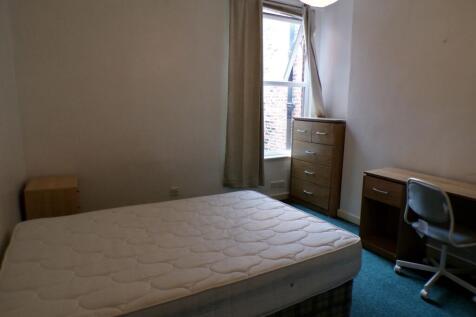 Bright, simply furnished bedroom with a large d...