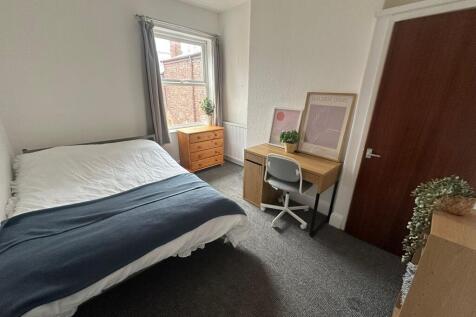 Bright and tidy bedroom featuring a comfortable...