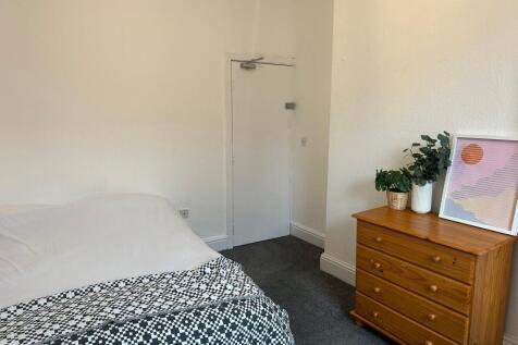 Cozy double bedroom featuring a well-made bed w...