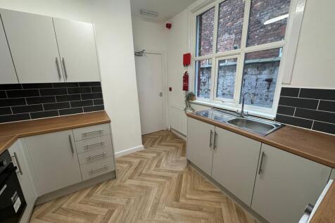 A bright and modern kitchen featuring white cab...