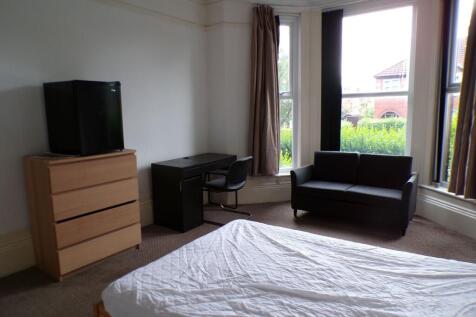 Bright bay-fronted master bedroom with large wi...