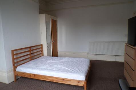 Bright, simply furnished bedroom with a wooden ...