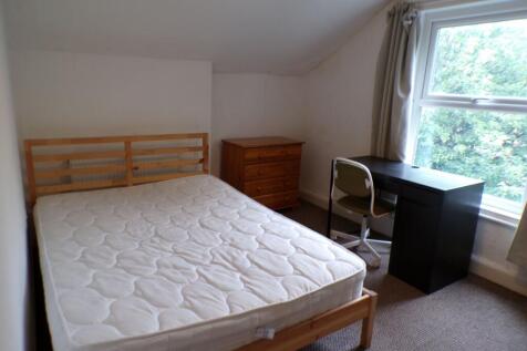 Bright, simply furnished bedroom with a double ...