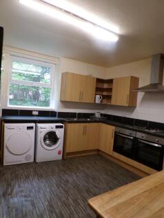 Bright fitted kitchen with modern wood-effect c...