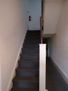 Carpeted internal staircase with a handrail lea...