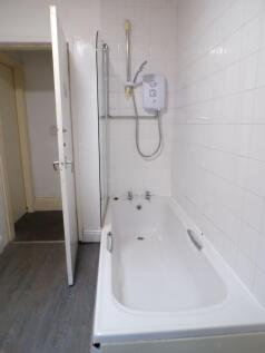 Bright, all-white bathroom featuring a full-siz...