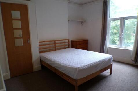 Bright double bedroom with a large window letti...