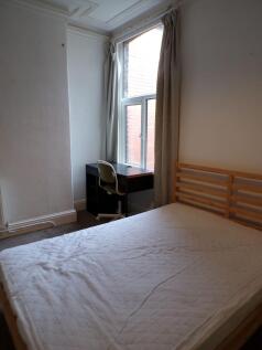 Bright bedroom with a wooden bed frame, mattres...