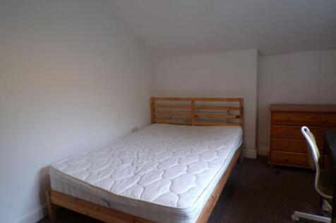 Bright, simply furnished bedroom with a wooden ...