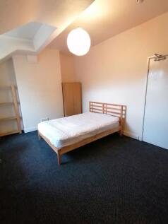 Bright, simply furnished bedroom with a double ...