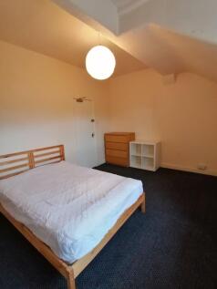 Bright, simply furnished bedroom with a wooden ...