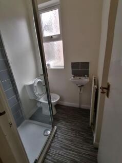 Compact bathroom with a tiled shower enclosure,...