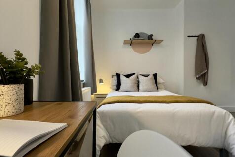 A stylish and well-lit double bedroom featuring...