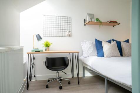 A bright and stylish double bedroom featuring a...