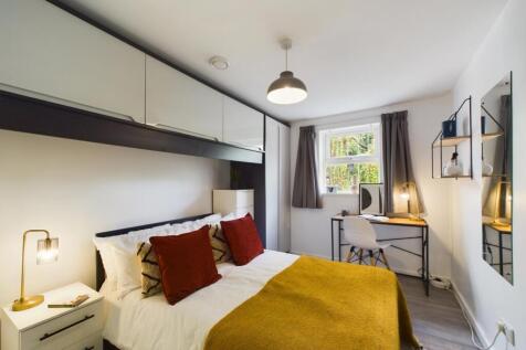 A bright and stylish double bedroom featuring a...