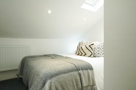 A clean and inviting double bedroom with cozy d...