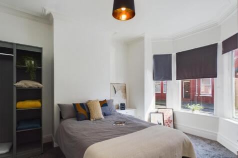 A bright and inviting double bedroom with styli...
