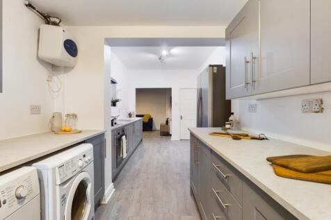 A bright and modern kitchen featuring ample cou...