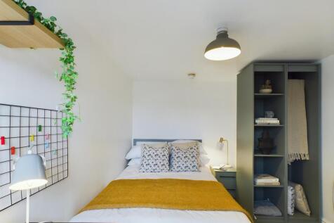 This inviting double bedroom features a cozy be...