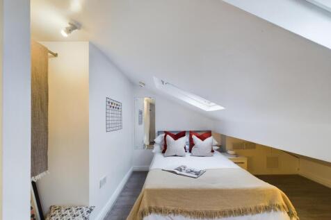 A cozy double bedroom featuring sloped ceilings...