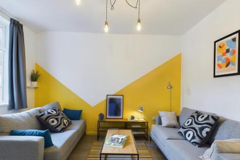 This vibrant living room features stylish grey ...