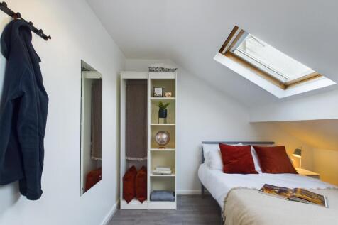 This inviting double bedroom features a cozy at...