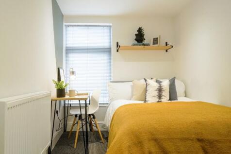 This cozy double bedroom features a comfortable...