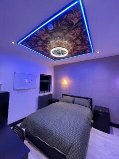 A stylish master bedroom featuring a comfortabl...