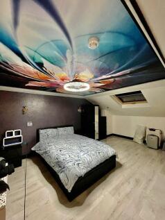 Spacious master bedroom featuring a striking ce...