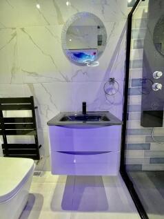 A modern bathroom featuring sleek white marble-...