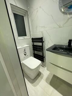 Modern and clean single toilet room featuring a...