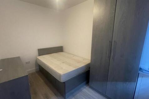 A cozy single bedroom featuring a bed and basic...