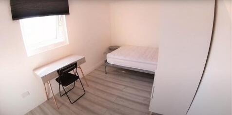 A neat and well-lit bedroom with a single bed p...