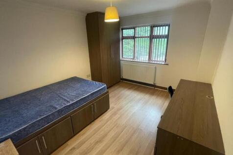 A well-lit, tidy student bedroom featuring a si...