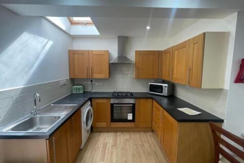 A modern, well-lit kitchen with wooden cabinets...