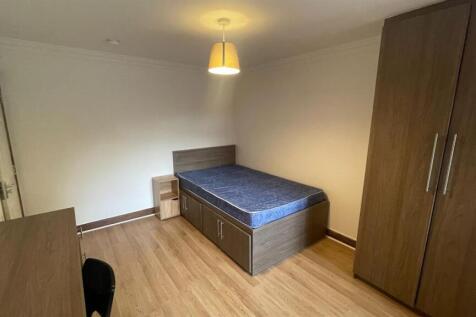 A neat and well-lit single bedroom featuring a ...