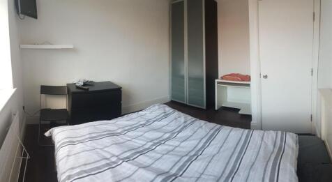 A cozy single bedroom featuring a neatly made b...