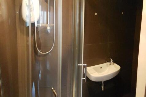 A modern bathroom featuring a glass-enclosed sh...